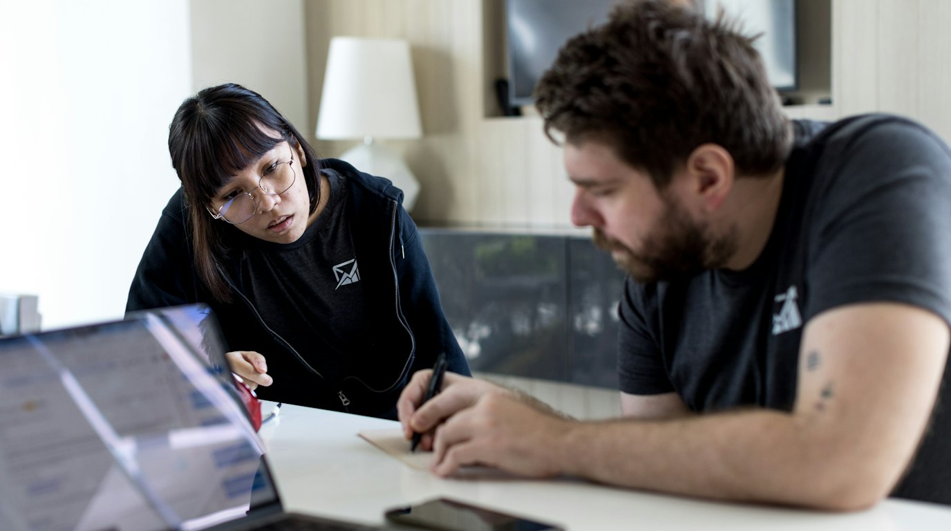 Two people reviewing information together on a laptop at a table