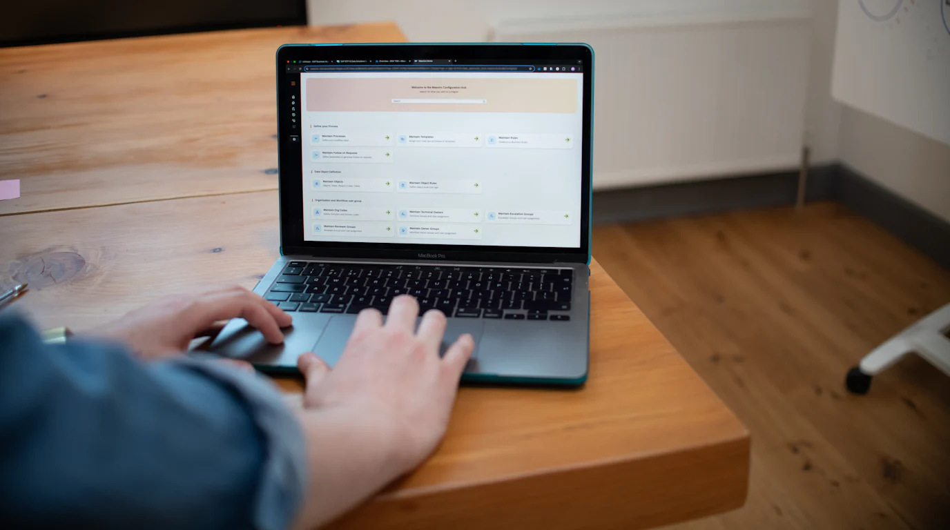 Person using a laptop on a wooden office desk