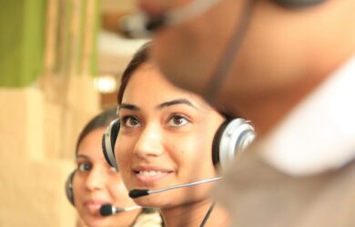 Two support team members wearing headsets at their computers