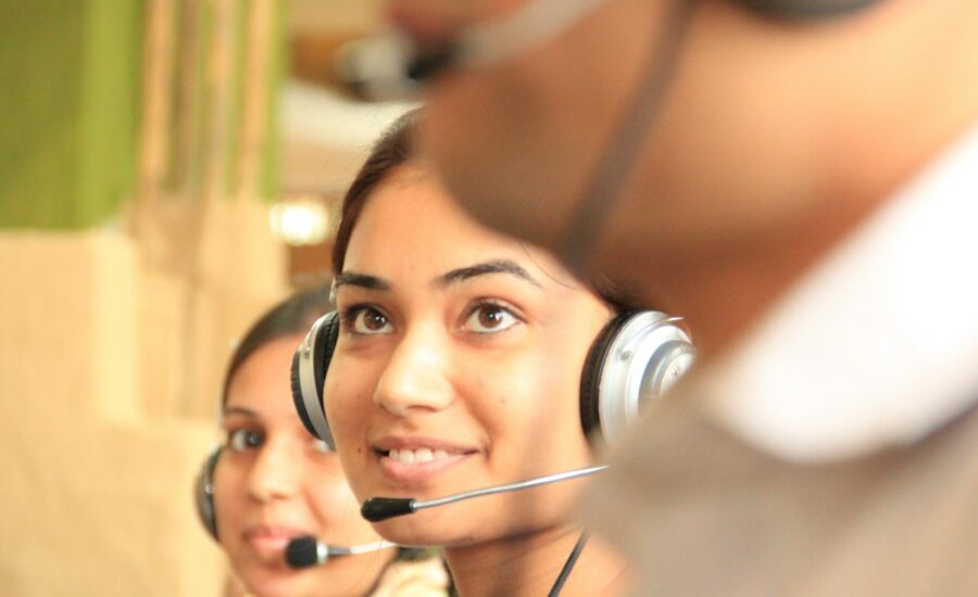 Two support team members wearing headsets at their computers